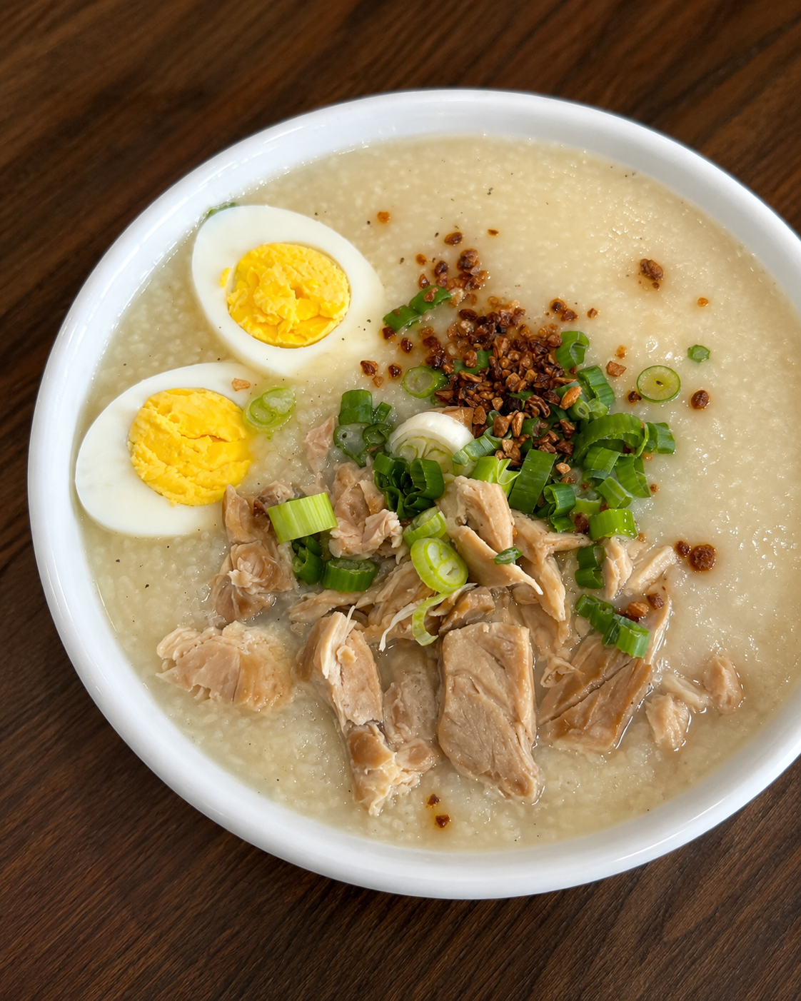Arroz Caldo — Filipino chicken and rice porridge topped with boiled egg, scallions, and toasted garlic