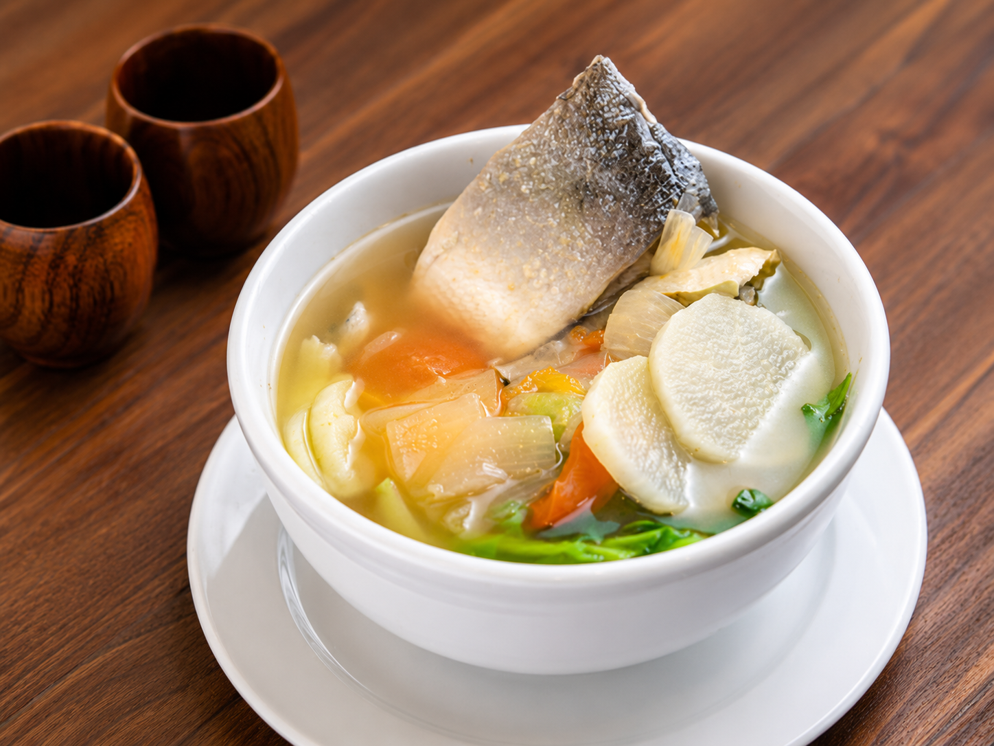 Bowl of Filipino fish sinigang soup with vegetables in clear tamarind broth